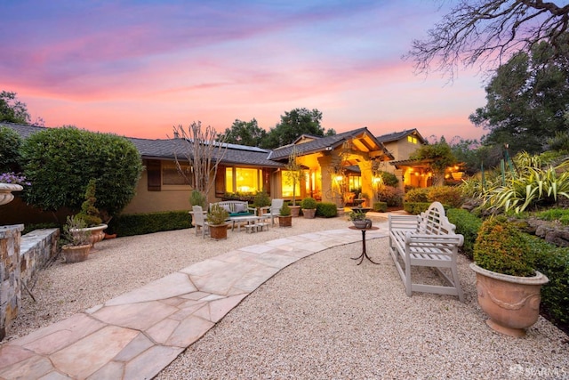 back of house with stucco siding, outdoor lounge area, and a patio