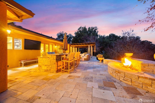 view of patio with an outdoor fire pit, outdoor dry bar, an outdoor kitchen, and a pergola