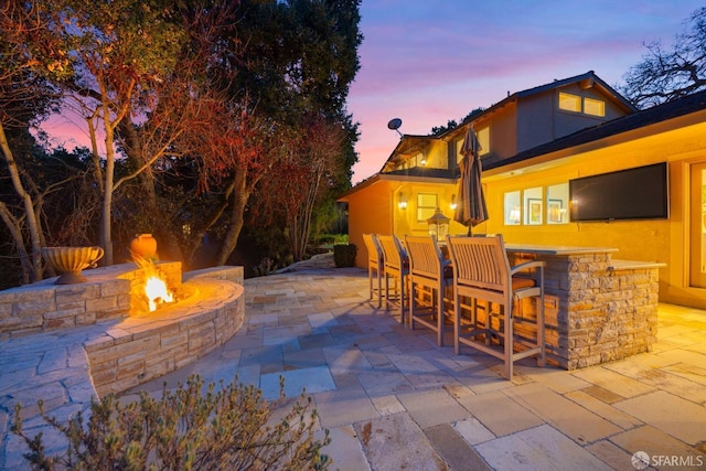 view of patio / terrace featuring outdoor dry bar and a fire pit