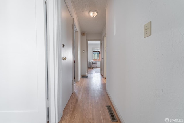 262 Topeka Ave, San Francisco, CA 94124 - hall with light wood-style floors, a textured ceiling, and baseboards