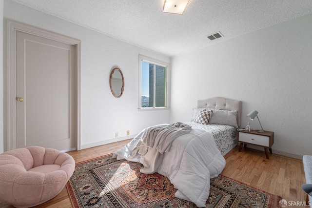 262 Topeka Ave, San Francisco, CA 94124 - bedroom with light wood-style floors, a textured ceiling, and baseboards