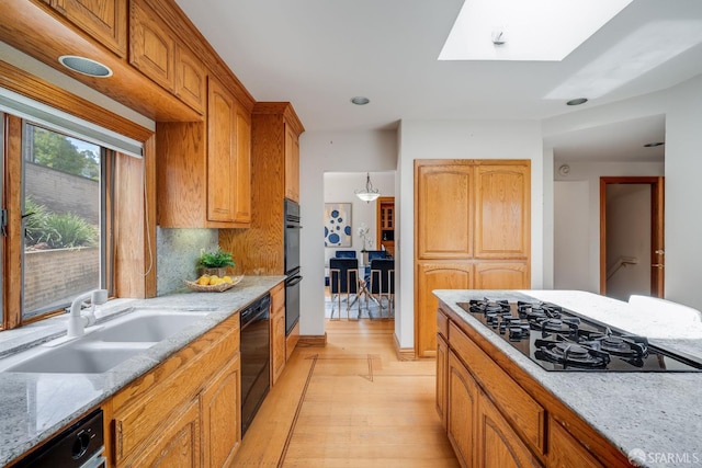 66 Baldwin Ave, Crockett, CA 94525 - kitchen featuring black appliances, light wood finished floors, light stone countertops, and a skylight