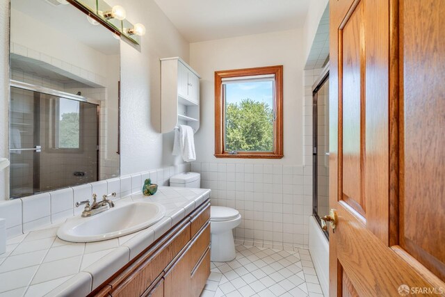 66 Baldwin Ave, Crockett, CA 94525 - bathroom with vanity, tile patterned flooring, tile walls, and combined bath / shower with glass door