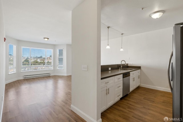 kitchen with dark wood-type flooring, white cabinets, a baseboard radiator, stainless steel appliances, and decorative light fixtures