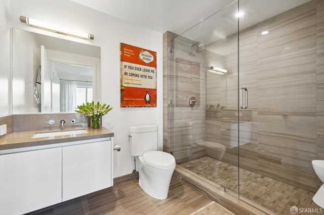 bathroom featuring toilet, an enclosed shower, and vanity