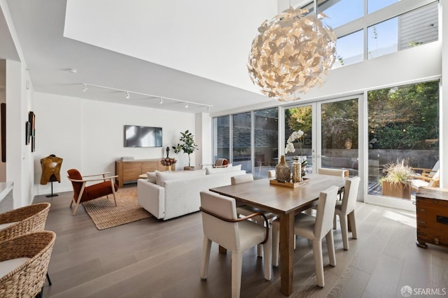 dining area featuring wood-type flooring and a notable chandelier