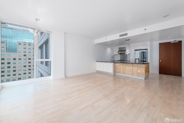 unfurnished living room with light hardwood / wood-style floors and sink