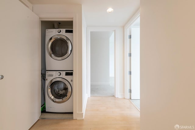 laundry room featuring light hardwood / wood-style flooring and stacked washer / drying machine