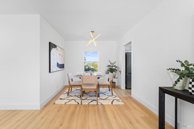 dining space with light wood-type flooring and baseboards