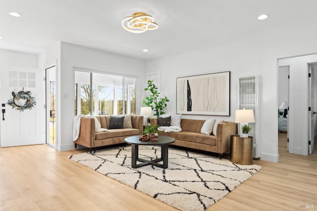 living area with baseboards, wood finished floors, and recessed lighting