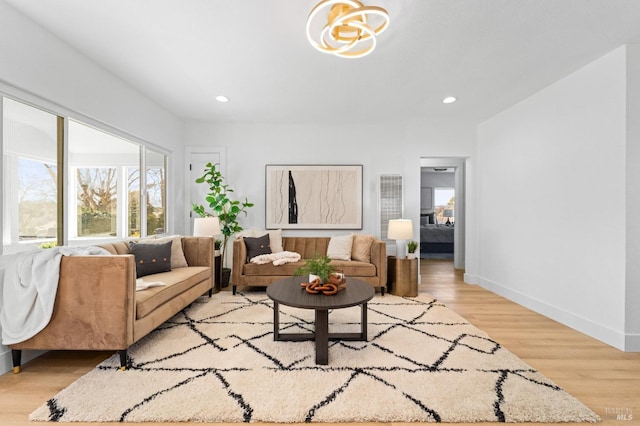 living room with light wood-style floors, recessed lighting, and baseboards