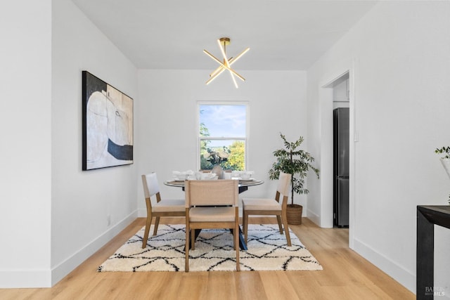 dining room featuring light wood finished floors and baseboards