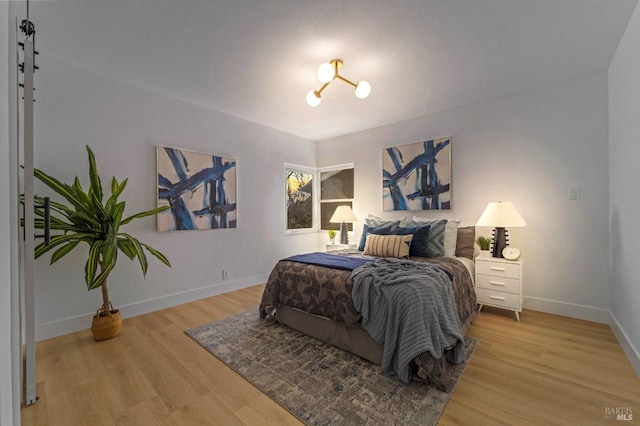 bedroom featuring baseboards and wood finished floors