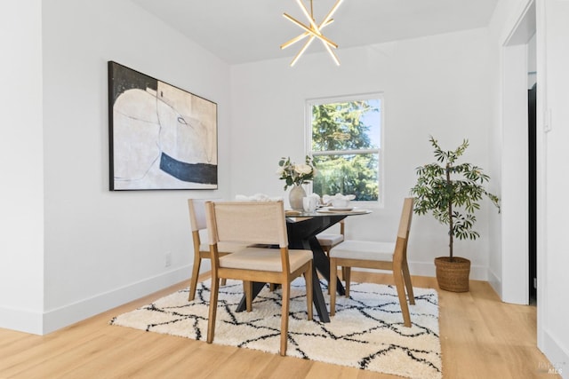 dining area with an inviting chandelier, baseboards, and wood finished floors