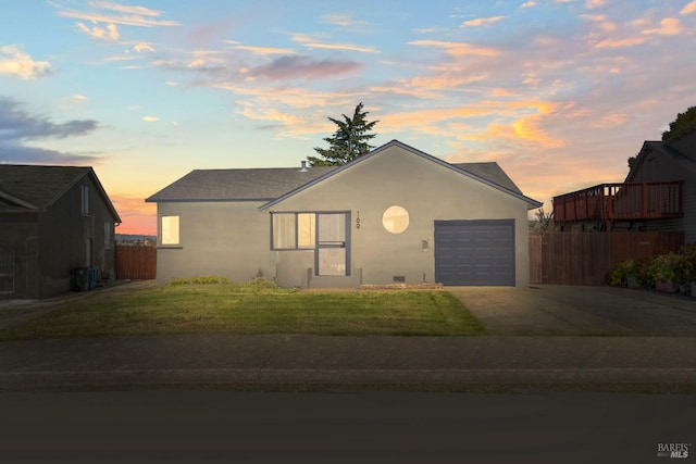 ranch-style home with stucco siding, concrete driveway, a front yard, fence, and a garage