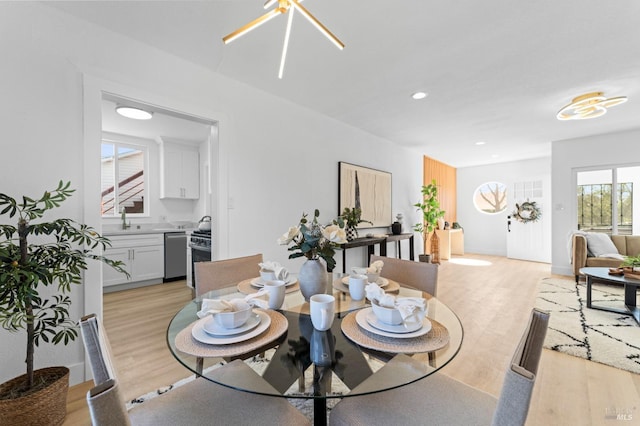 dining room with light wood finished floors, baseboards, and recessed lighting