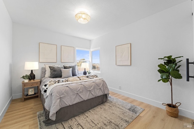 bedroom featuring light wood-type flooring and baseboards