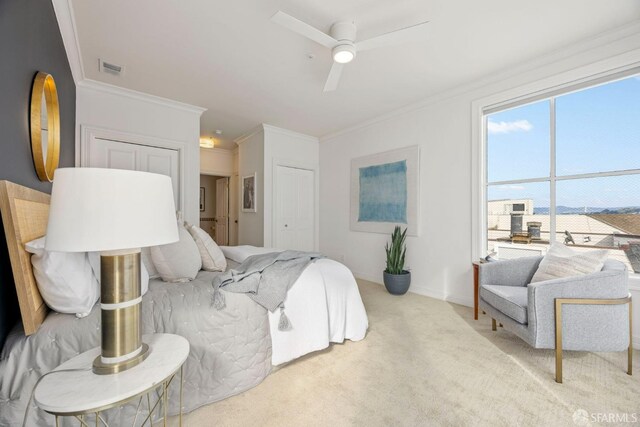 carpeted bedroom featuring visible vents, crown molding, baseboards, and ceiling fan