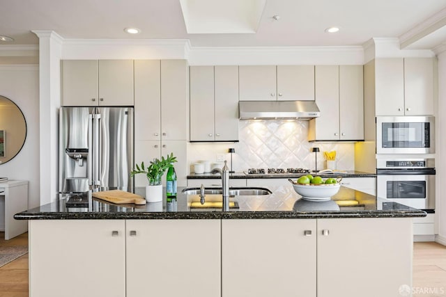 kitchen with a center island with sink, appliances with stainless steel finishes, light wood-style floors, a sink, and under cabinet range hood