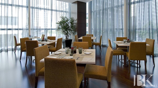 dining area with a wall of windows and wood finished floors