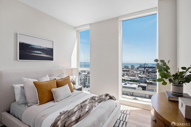 bedroom featuring hardwood / wood-style flooring and expansive windows