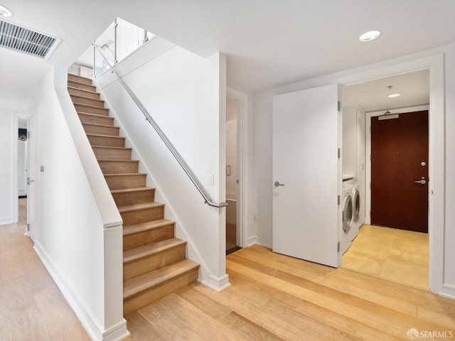 stairway featuring hardwood / wood-style floors and washer and dryer