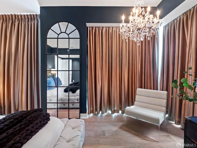 living area with hardwood / wood-style floors and an inviting chandelier