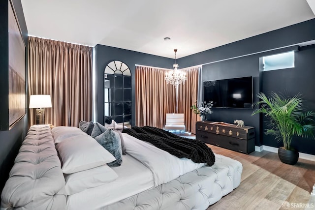 bedroom featuring wood-type flooring and an inviting chandelier