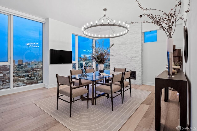 dining area with light wood-type flooring and a chandelier