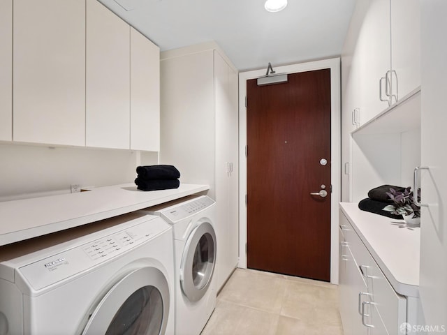 washroom with washing machine and dryer, light tile patterned flooring, and cabinets