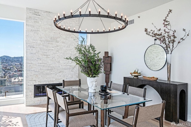 dining room with a chandelier and a fireplace