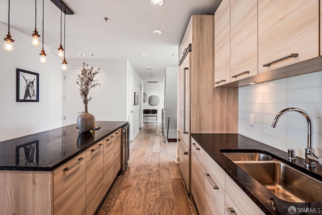 kitchen featuring light brown cabinets, hardwood / wood-style flooring, and sink