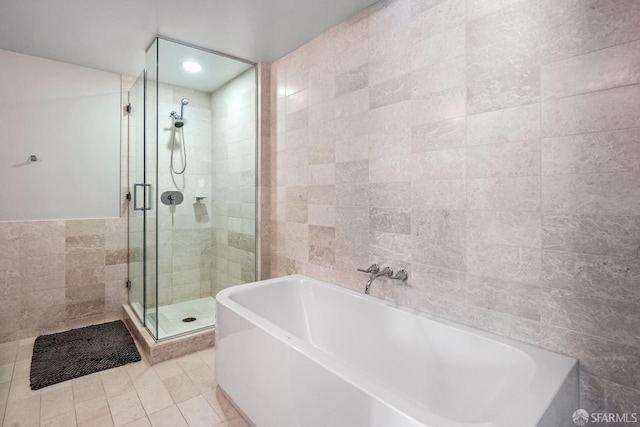 bathroom with plus walk in shower, tile walls, and tile patterned floors