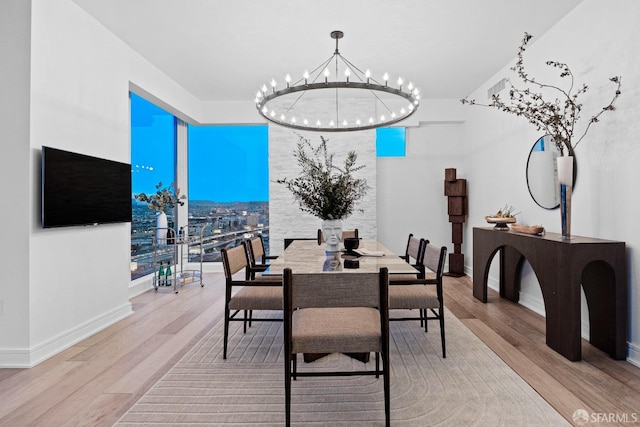 dining area featuring light hardwood / wood-style flooring, french doors, and a notable chandelier