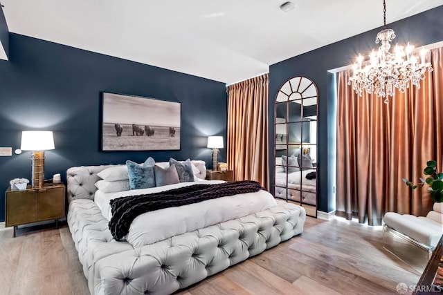 bedroom with wood-type flooring and a chandelier