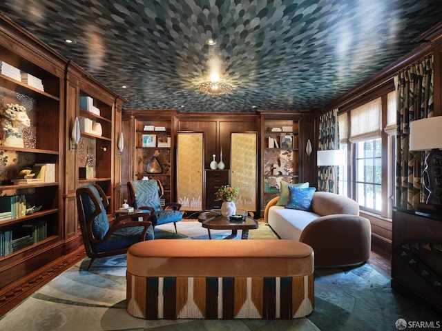 living area with ornamental molding, wooden walls, built in features, and wood finished floors