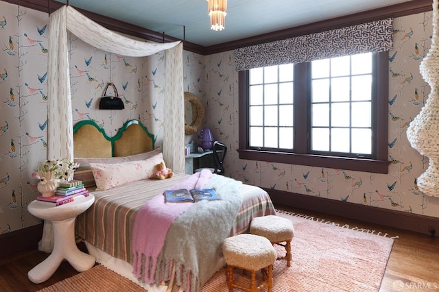bedroom featuring wallpapered walls, wood finished floors, and baseboards