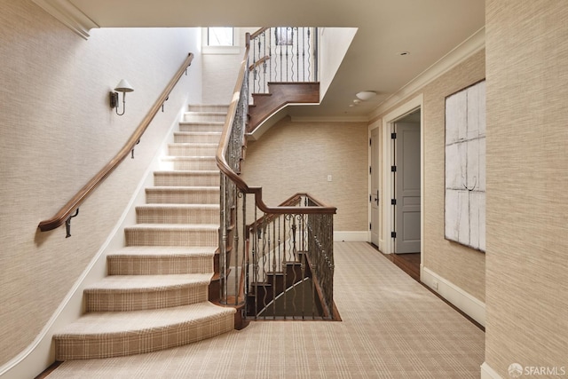 stairs with crown molding, carpet flooring, and baseboards