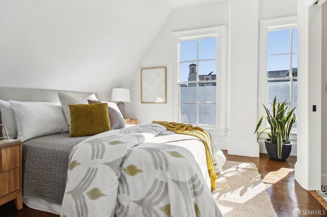 bedroom with vaulted ceiling and dark hardwood / wood-style flooring