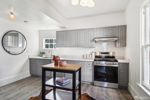 kitchen featuring stainless steel range with gas cooktop, sink, and gray cabinetry