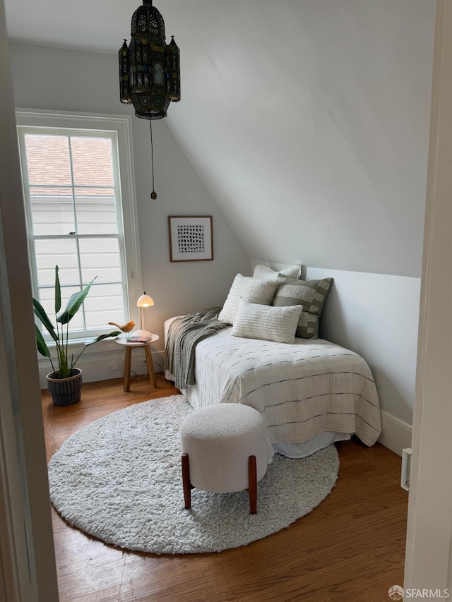 bedroom featuring hardwood / wood-style flooring and vaulted ceiling