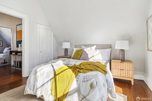 bedroom featuring lofted ceiling and dark hardwood / wood-style floors