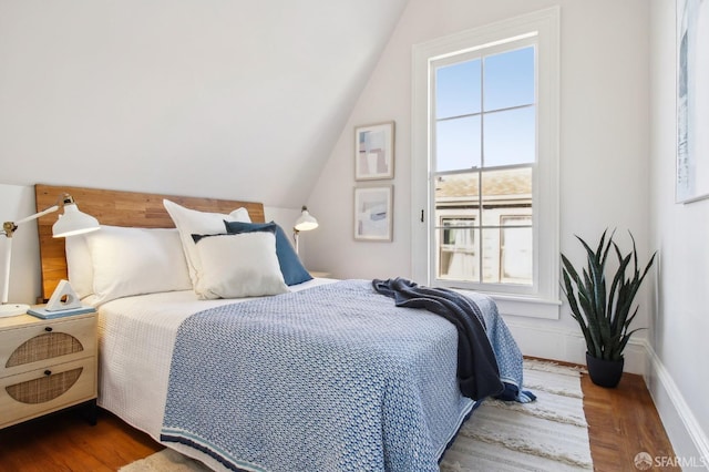 bedroom with lofted ceiling and dark hardwood / wood-style floors