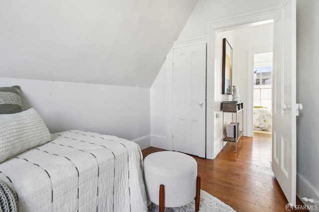 bedroom with hardwood / wood-style floors and vaulted ceiling