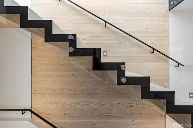 stairs featuring wood walls