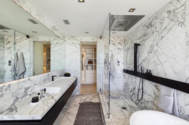 bathroom featuring a shower with shower door and vanity