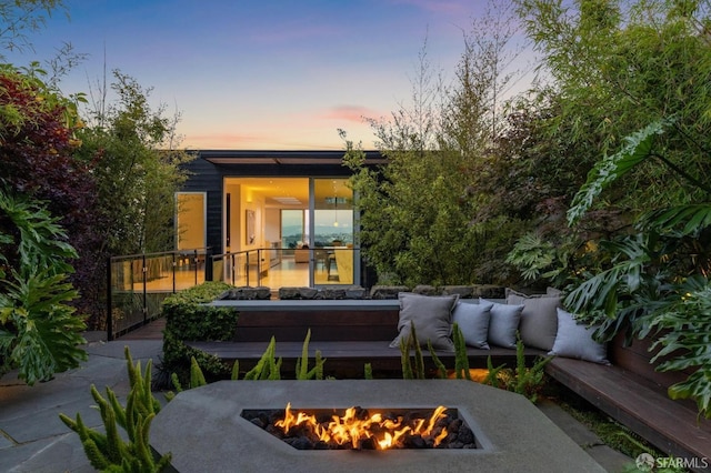 patio terrace at dusk featuring an outdoor fire pit