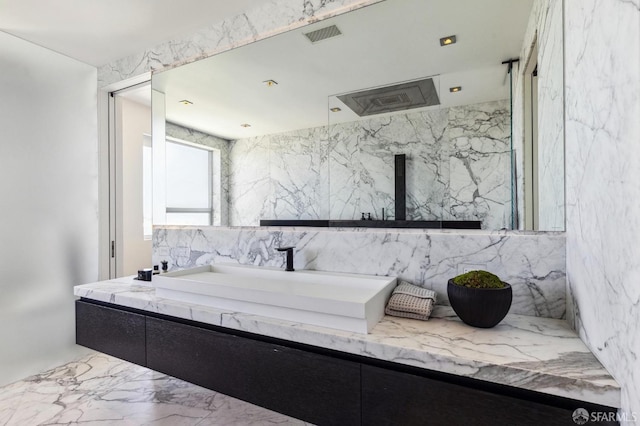 bathroom featuring vanity and tile walls