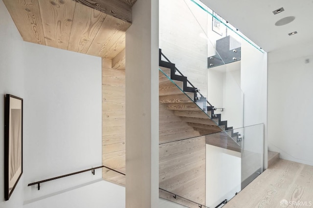 stairs with wooden ceiling, hardwood / wood-style floors, and wooden walls