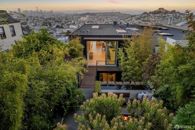 back house at dusk with an outdoor living space